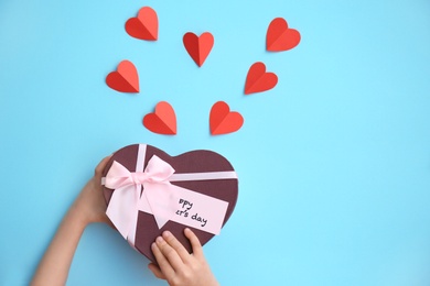 Photo of Child holding gift box for Mother's Day on color background