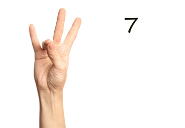 Woman showing number seven on white background, closeup. Sign language