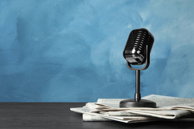 Photo of Newspapers and vintage microphone on table, space for text. Journalist's work