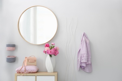 Photo of Stylish hallway interior with round mirror on white wall