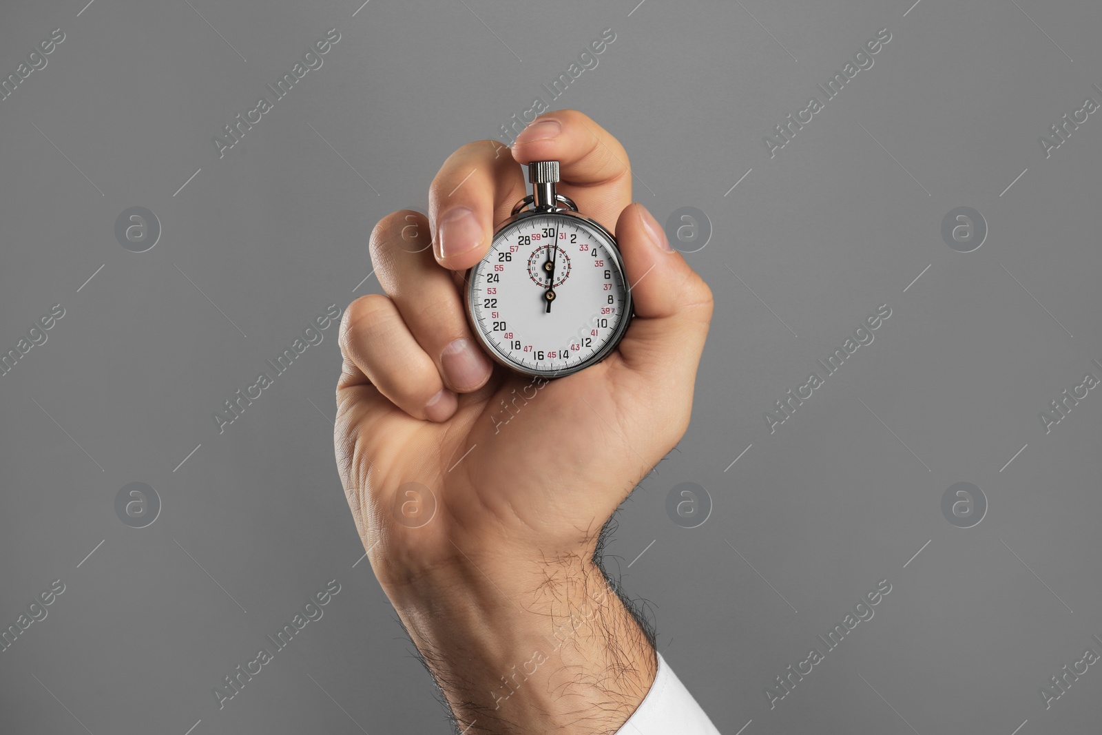 Photo of Man holding vintage timer on grey background, closeup