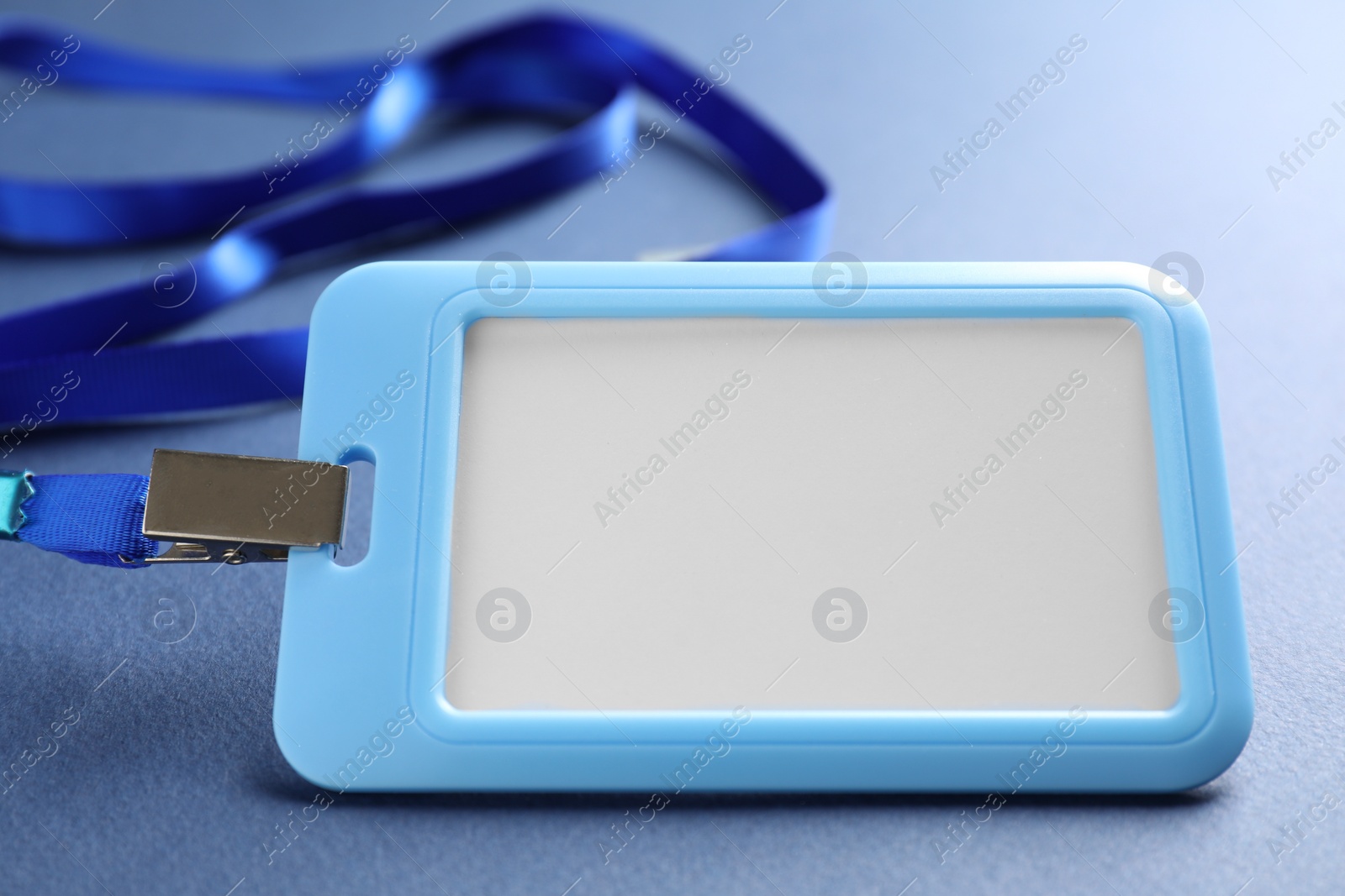 Photo of Blank badge with string on blue background, closeup