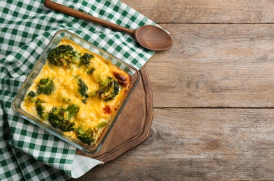 Photo of Flat lay composition with tasty broccoli casserole on wooden table. Space for text