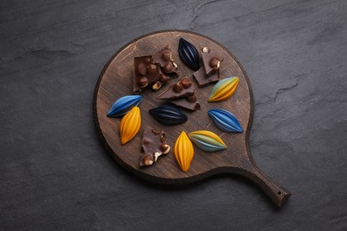 Photo of Tasty chocolate candies on black table, flat lay