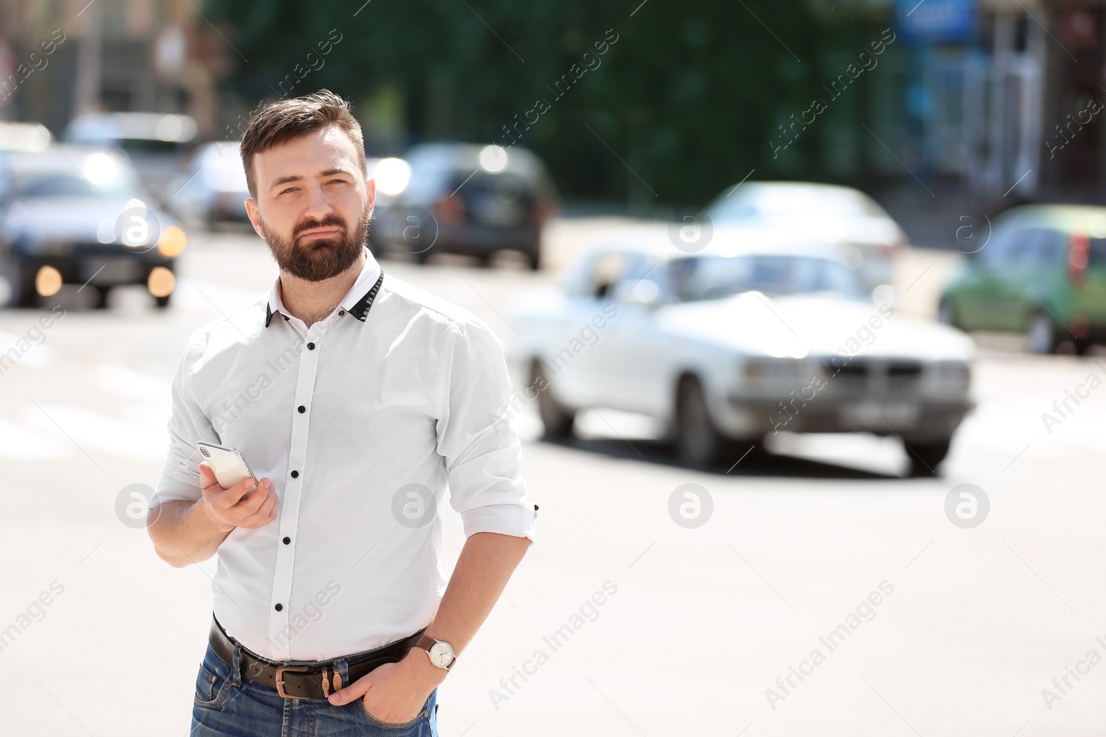 Photo of Portrait of young man with smartphone outdoors