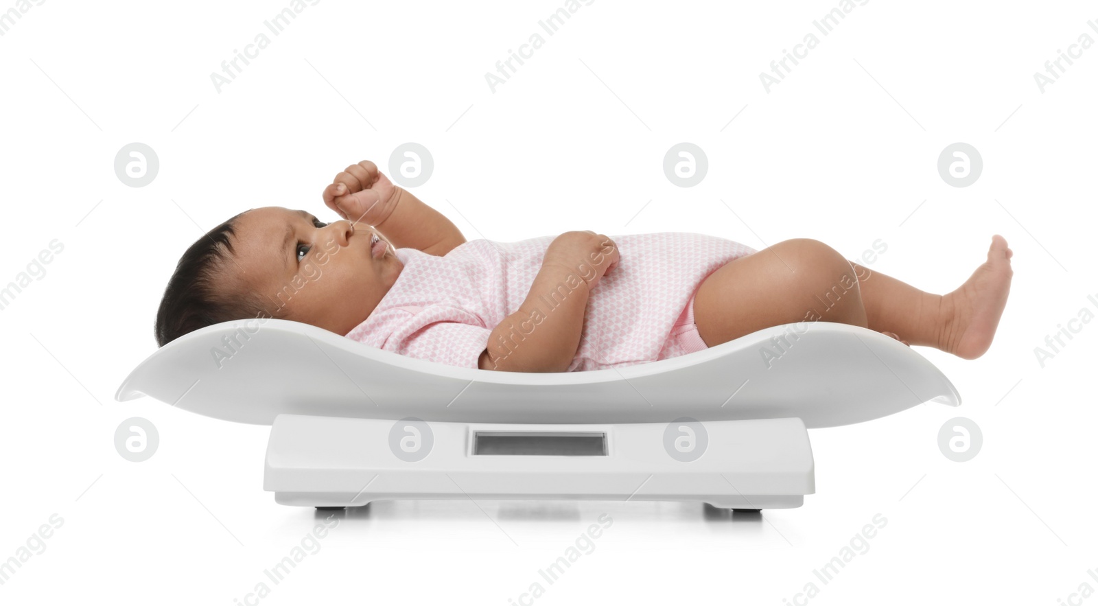 Photo of African-American baby lying on scales against white background