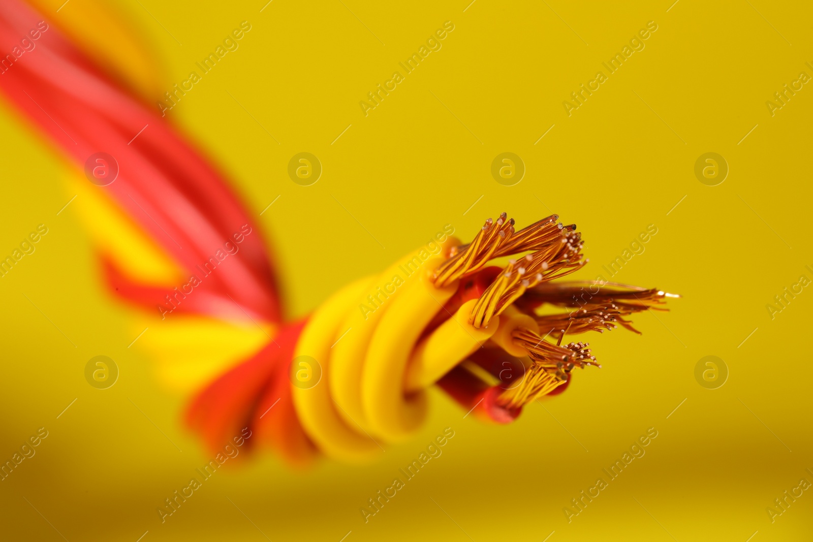 Photo of Electrical wires on yellow background, closeup view