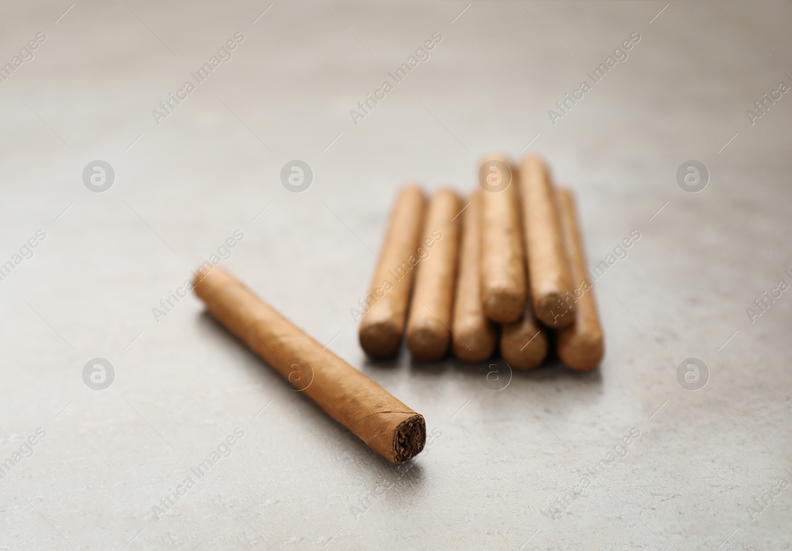 Photo of Many expensive cigars on light grey table