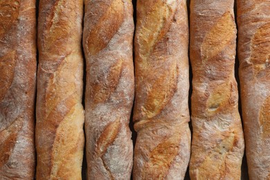 Photo of Crispy French baguettes as background, top view. Fresh bread