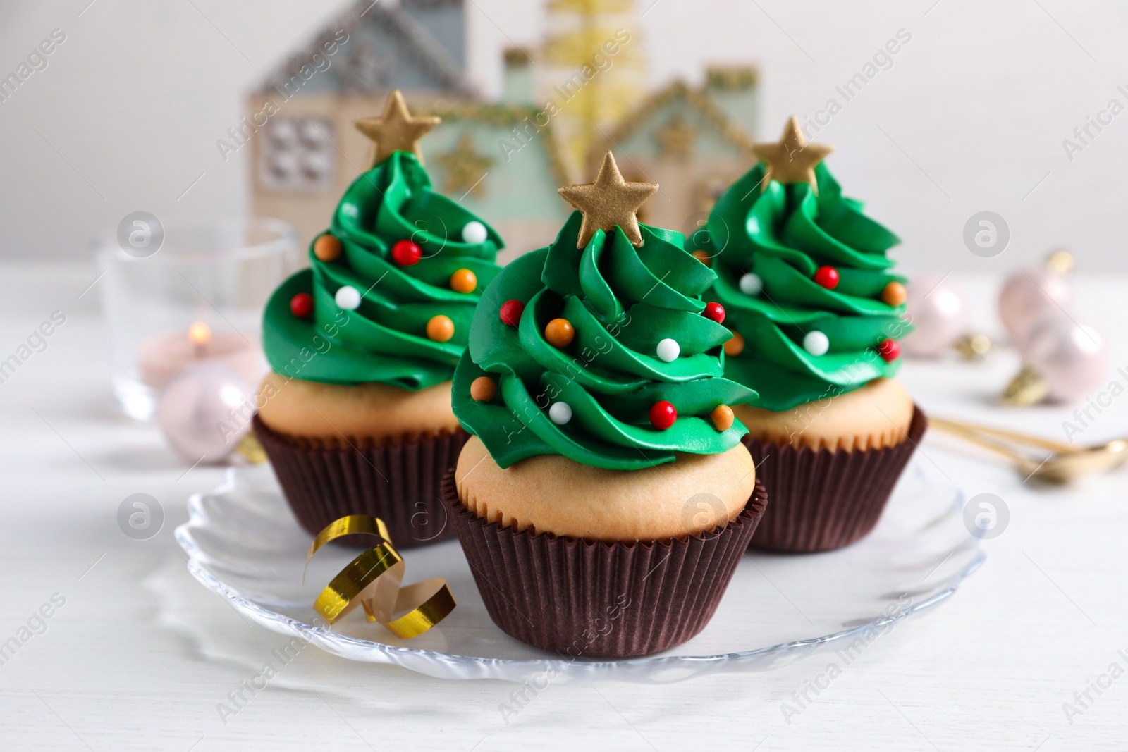 Photo of Christmas tree shaped cupcakes on white table