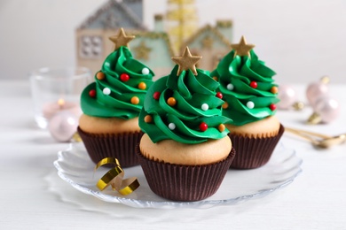 Photo of Christmas tree shaped cupcakes on white table