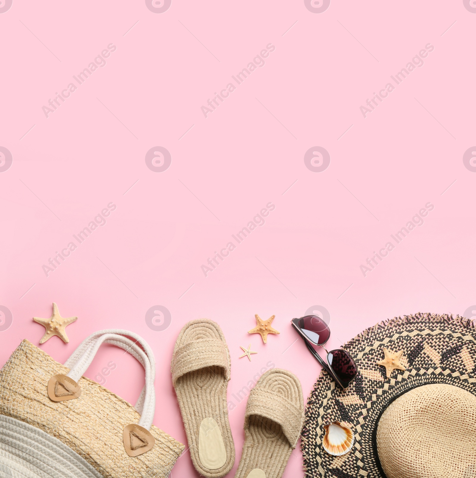 Photo of Beach accessories on pink background, flat lay. Space for text