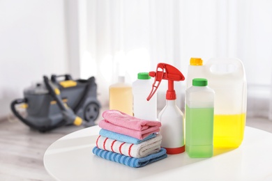 Photo of Set of professional cleaning supplies on table indoors. Space for text