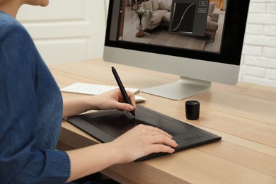 Professional retoucher working on graphic tablet at desk, closeup