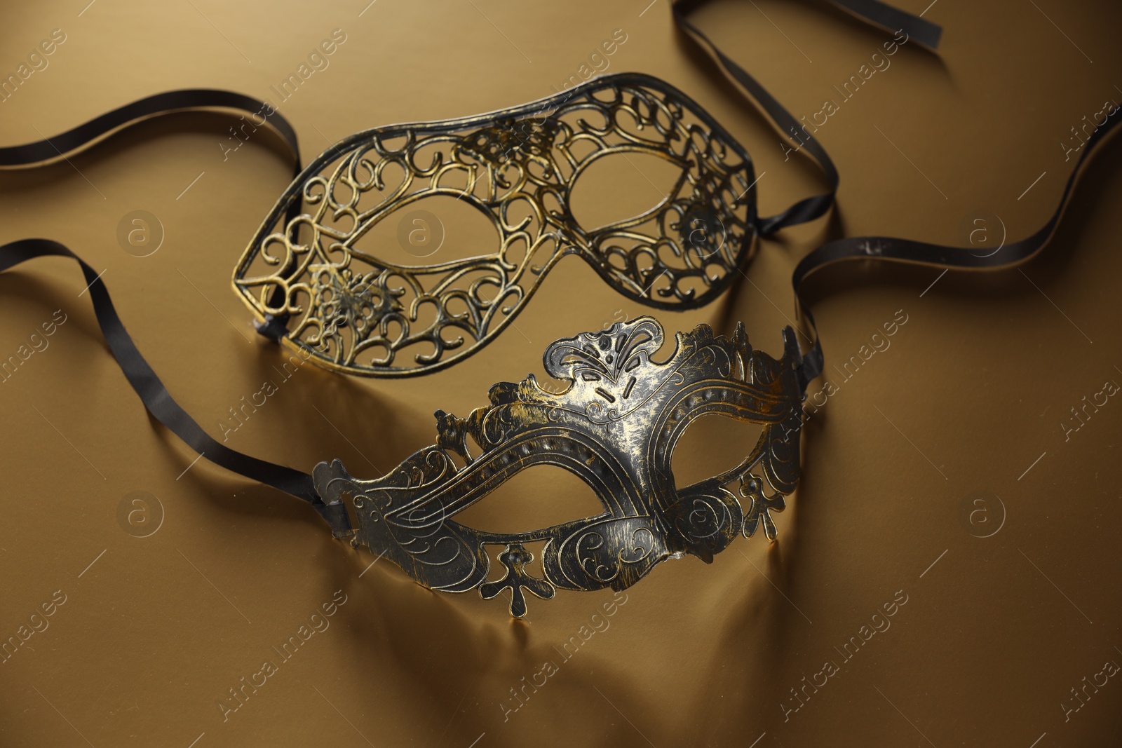 Photo of Elegant face masks on beige background. Theatrical performance