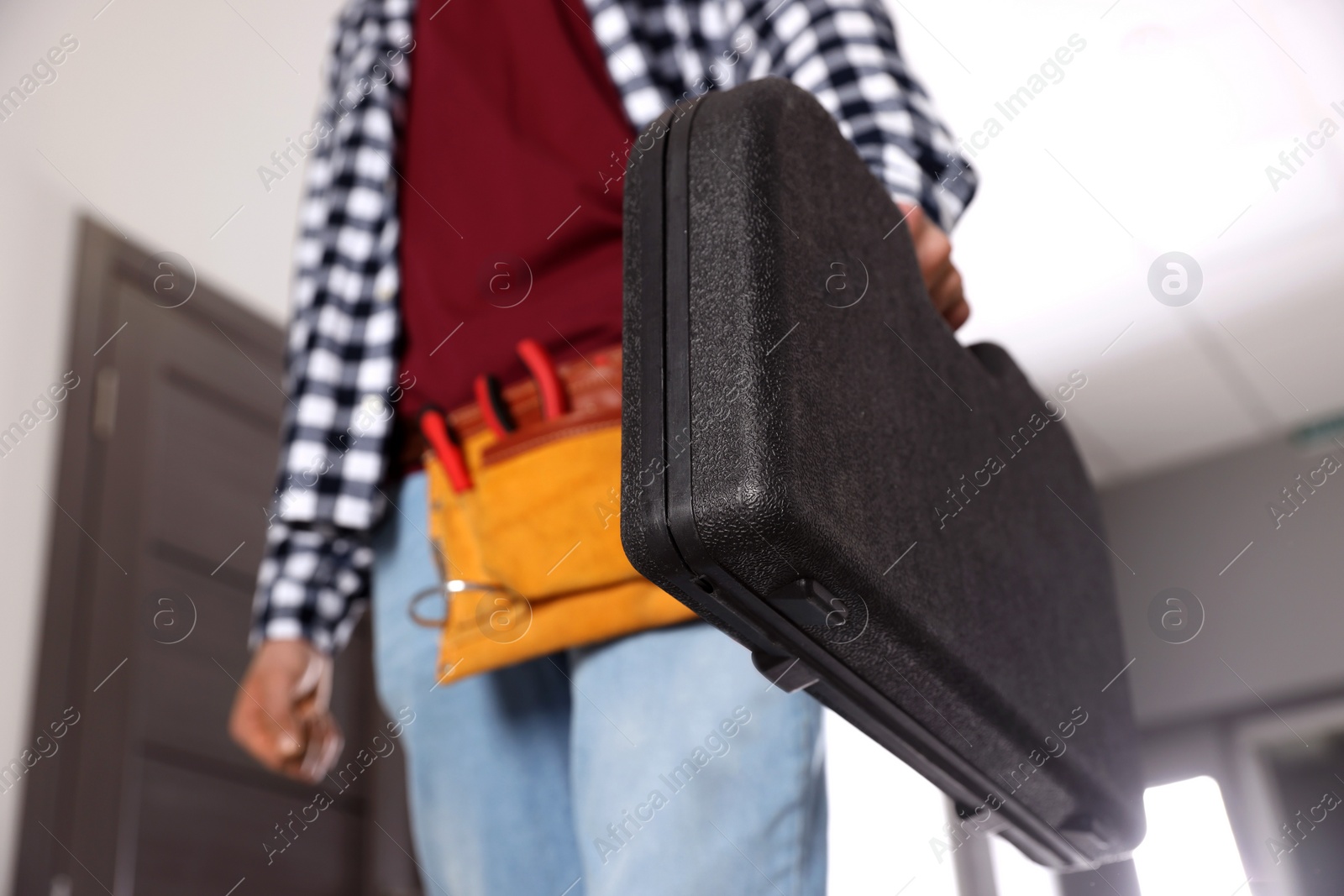 Photo of Handyman with tools indoors, closeup. Low angle view