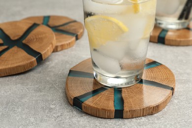 Cocktail and stylish cup wooden coasters on light grey table