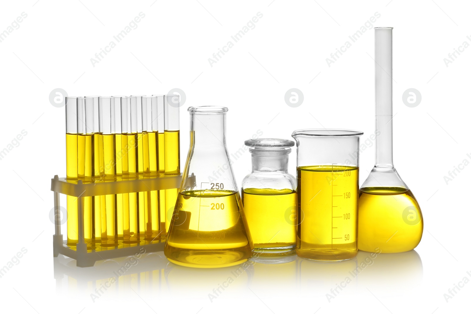 Photo of Laboratory glassware with yellow liquid on white background