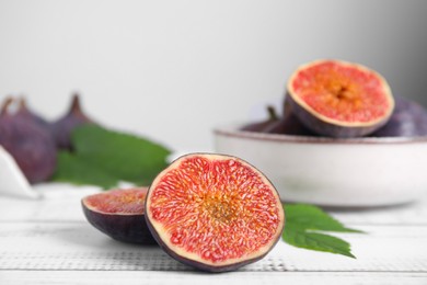 Photo of Fresh ripe figs on white wooden table, closeup