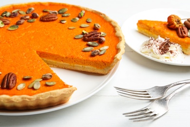 Photo of Delicious homemade pumpkin pie on white wooden table, closeup