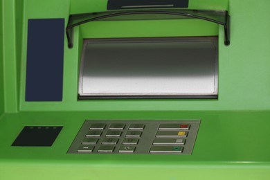 Photo of Modern automated cash machine with keypad outdoors