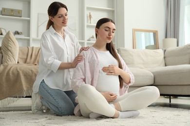 Doula taking care of pregnant woman at home. Preparation for child birth