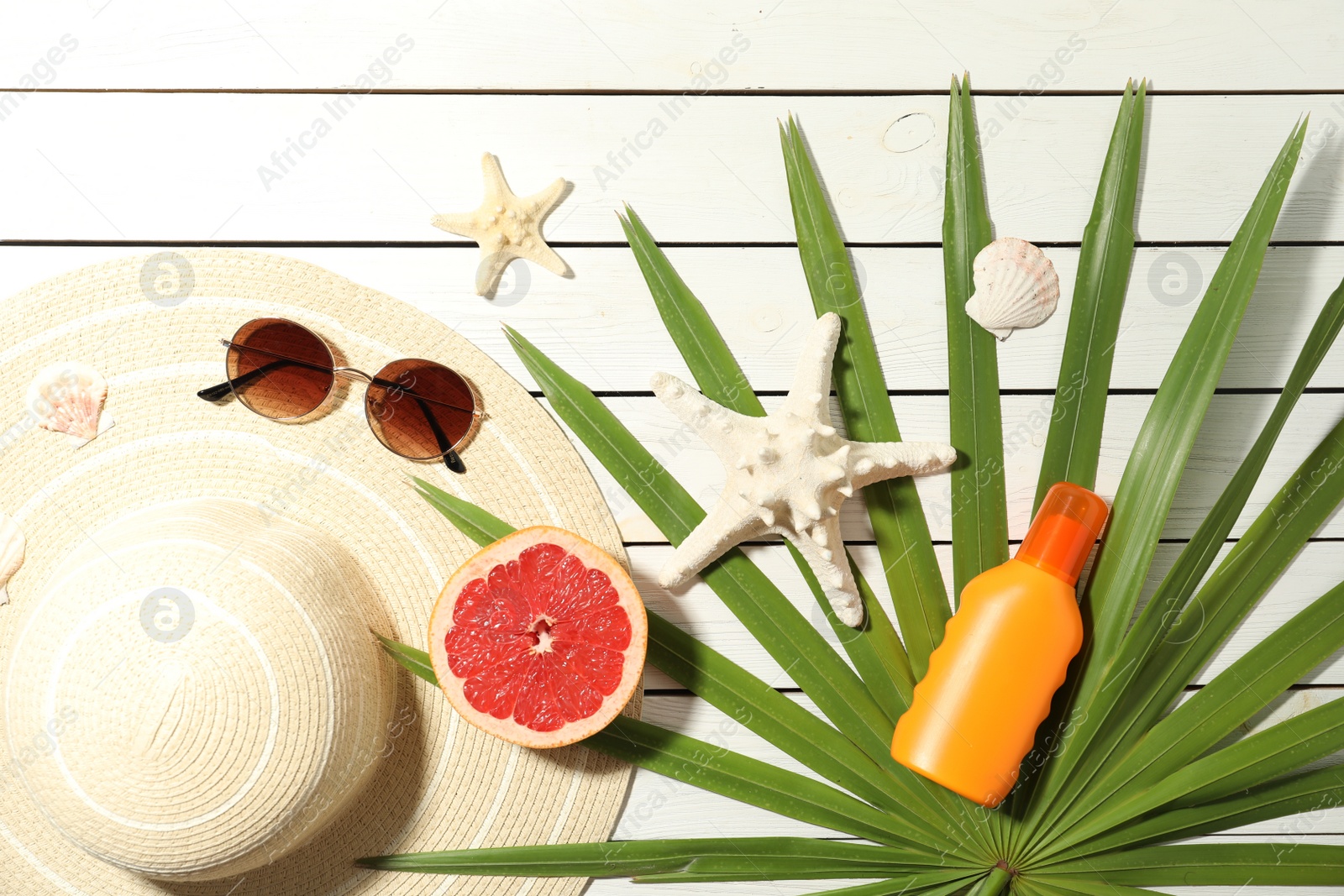 Photo of Flat lay composition with grapefruit and beach objects on white wooden background