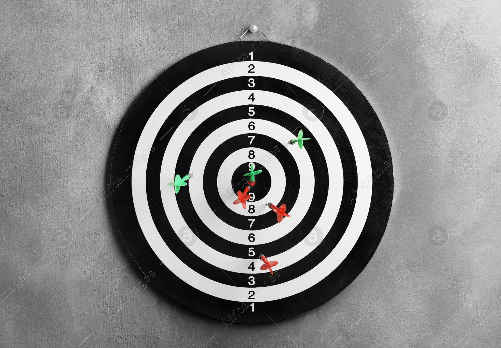 Photo of Arrows hitting dart board on grey wall