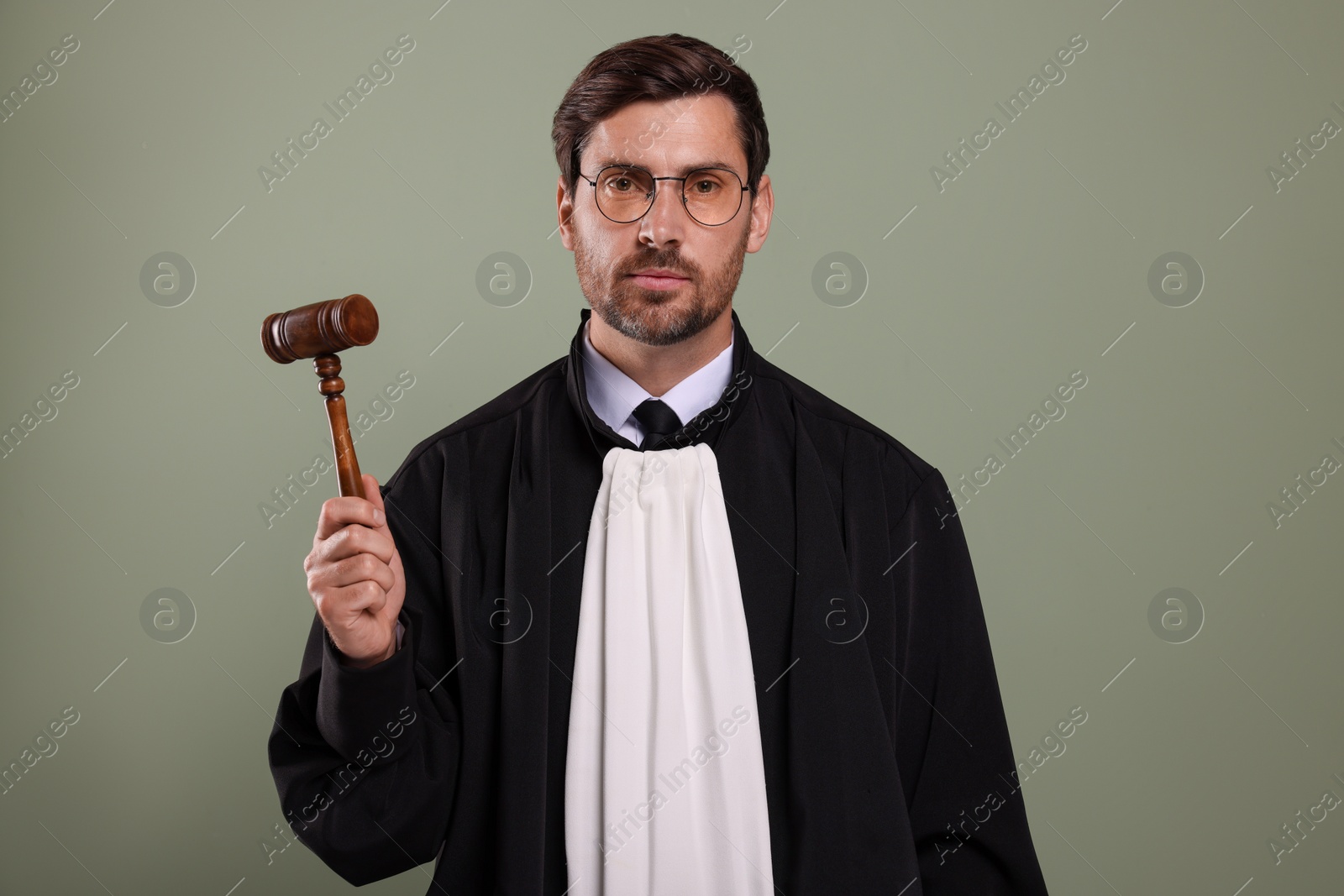 Photo of Portrait of judge with gavel on green background