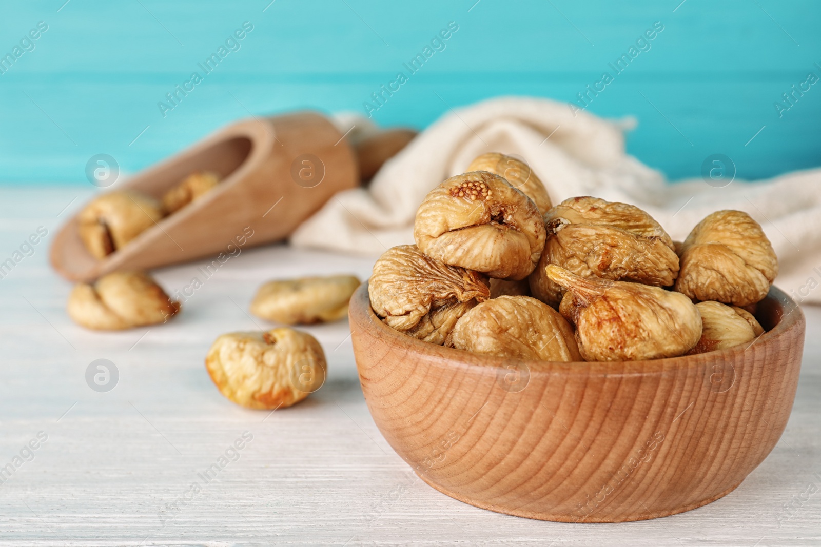 Photo of Wooden bowl of dried figs on table, closeup with space for text. Healthy fruit