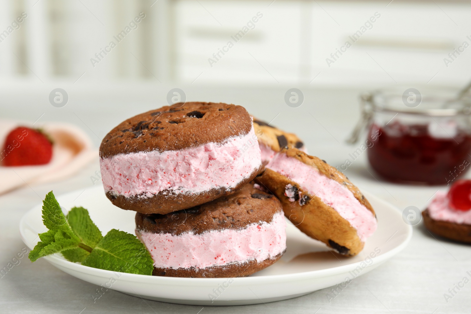 Photo of Plate with sweet delicious ice cream cookie sandwiches on table