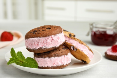 Photo of Plate with sweet delicious ice cream cookie sandwiches on table