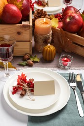 Beautiful autumn place setting with blank card and decor on table