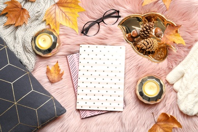 Photo of Flat lay composition with books, candles and autumn leaves on fuzzy rug