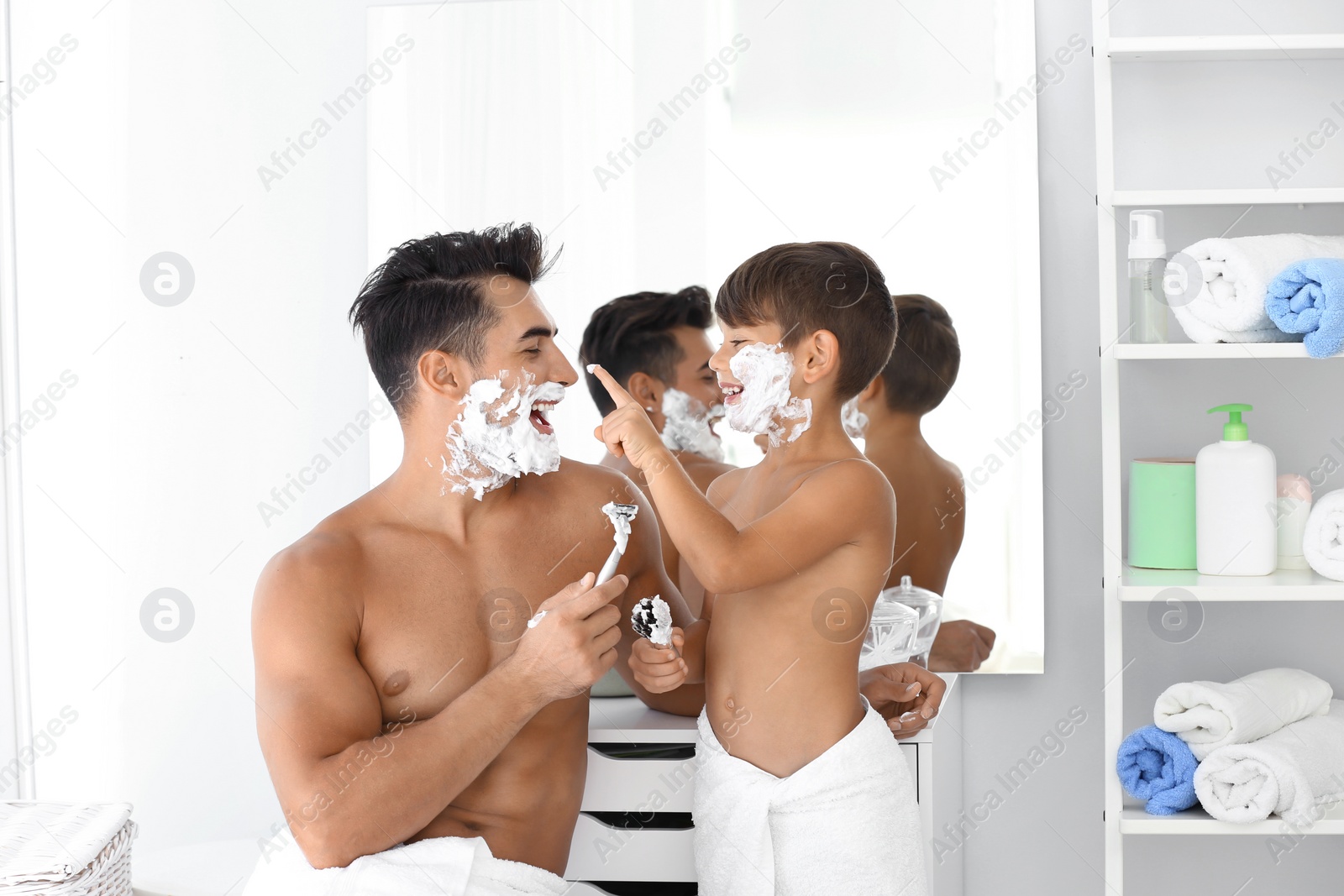 Photo of Father and son having fun while shaving in bathroom