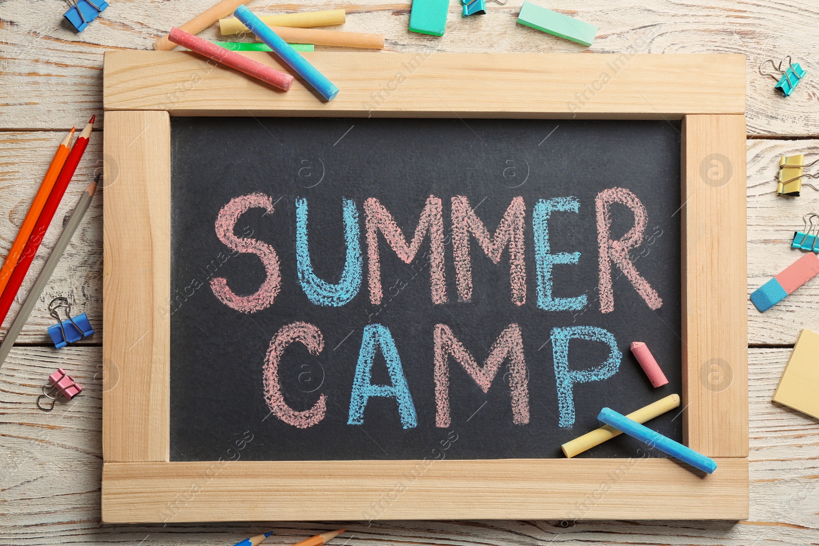 Photo of Text "SUMMER CAMP" on small blackboard and colorful chalk, top view