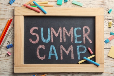 Text "SUMMER CAMP" on small blackboard and colorful chalk, top view