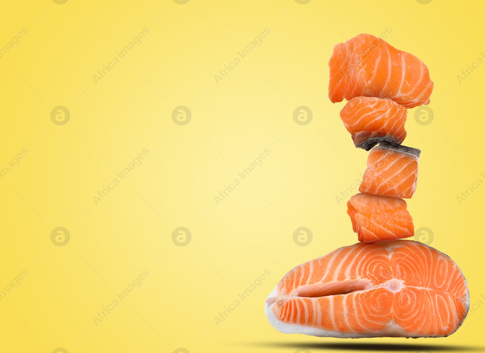 Image of Cut fresh salmon falling on yellow background, space for text