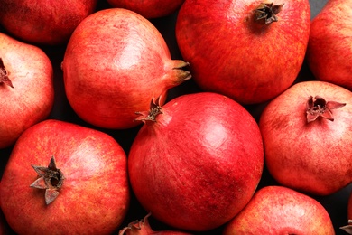 Ripe red pomegranates on grey background, top view