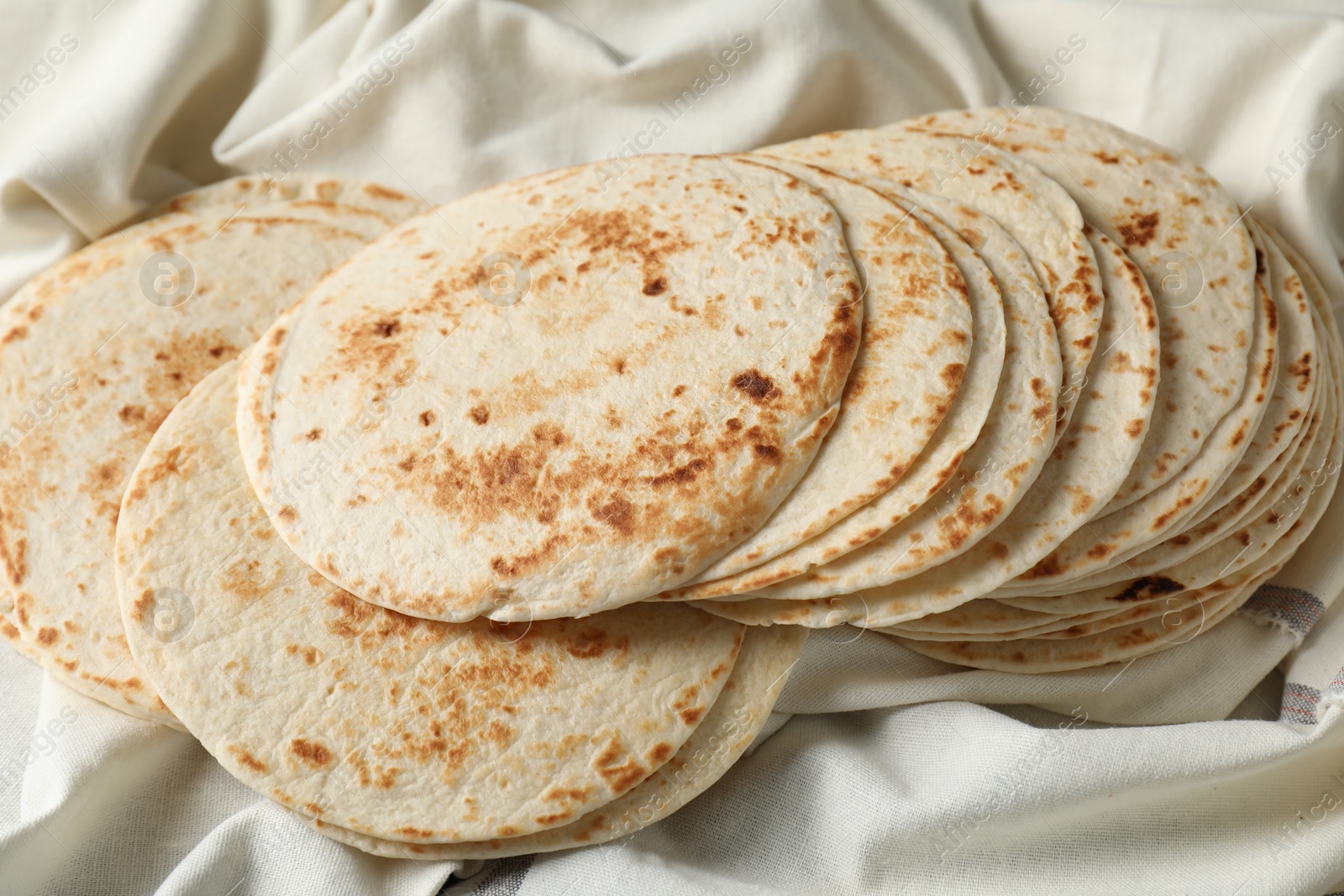 Photo of Tasty homemade tortillas and cloth on table