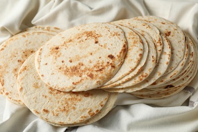 Tasty homemade tortillas and cloth on table