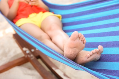 Photo of Young woman resting in comfortable hammock at seaside