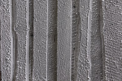 Photo of Wooden wall covered with hoarfrost on snowy day, closeup