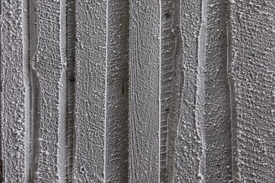 Wooden wall covered with hoarfrost on snowy day, closeup