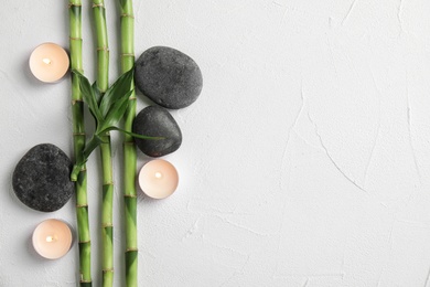 Photo of Flat lay composition with bamboo branches and spa stones on light background. Space for text