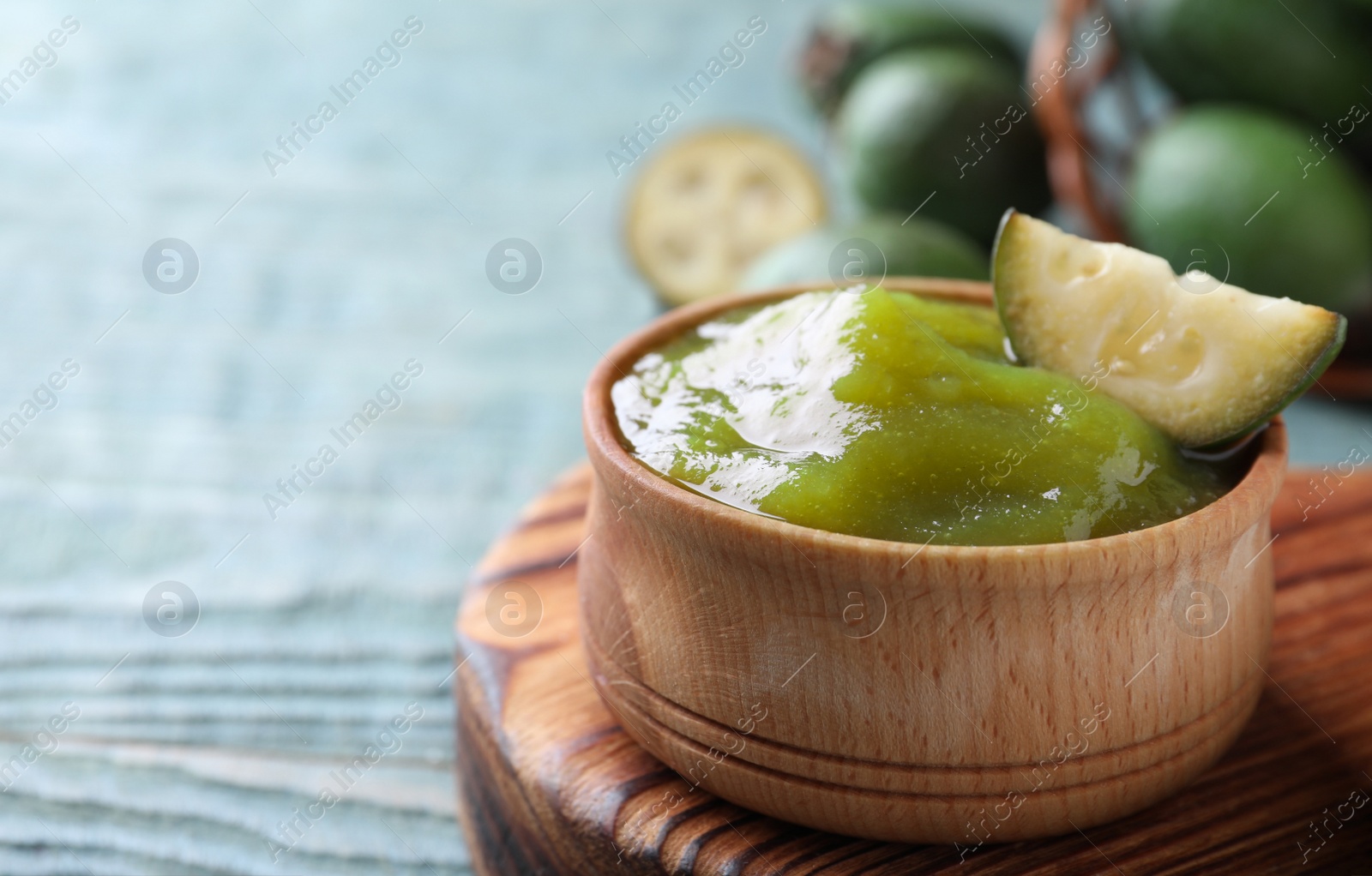 Photo of Feijoa jam and fresh fruit on light table, closeup. Space for text