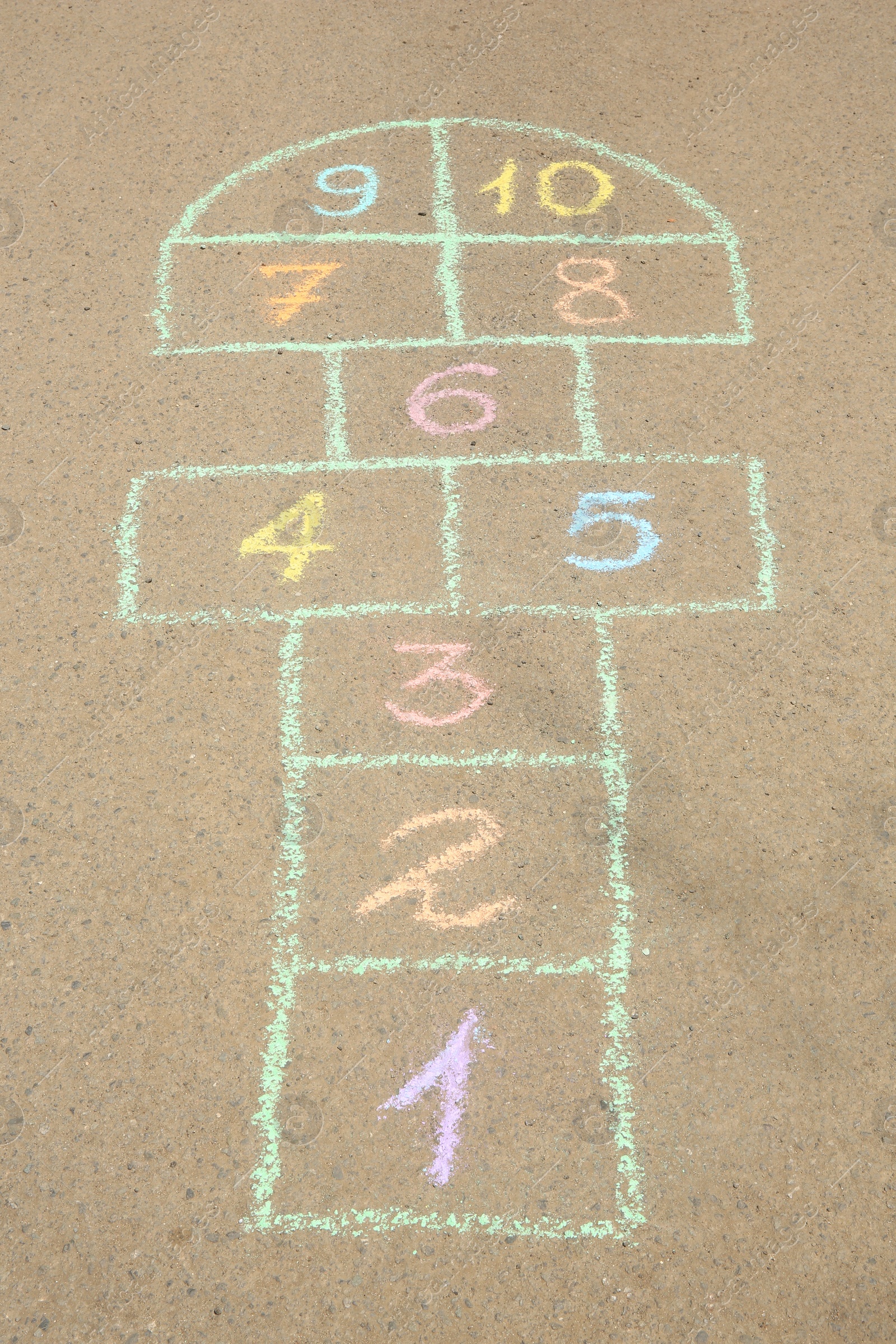 Photo of Hopscotch drawn with colorful chalk on asphalt outdoors