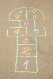 Hopscotch drawn with colorful chalk on asphalt outdoors