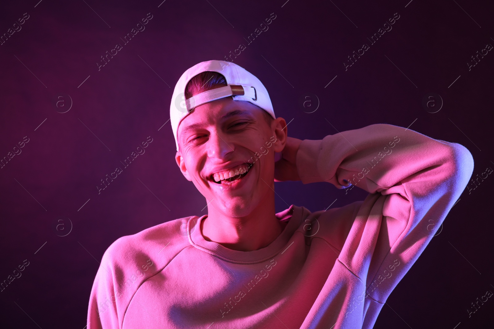 Photo of Young man on dark background in neon light