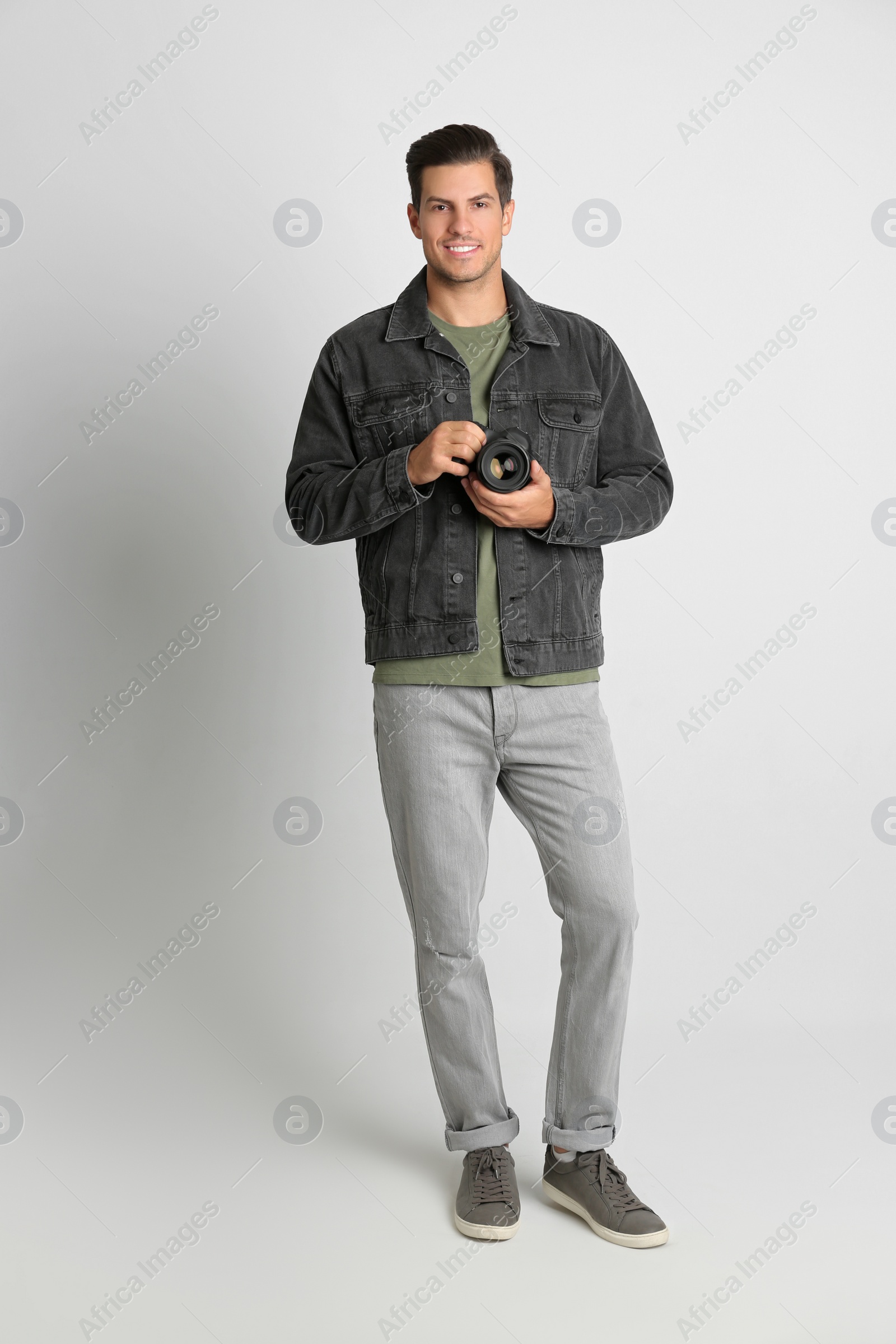 Photo of Professional photographer working on white background in studio